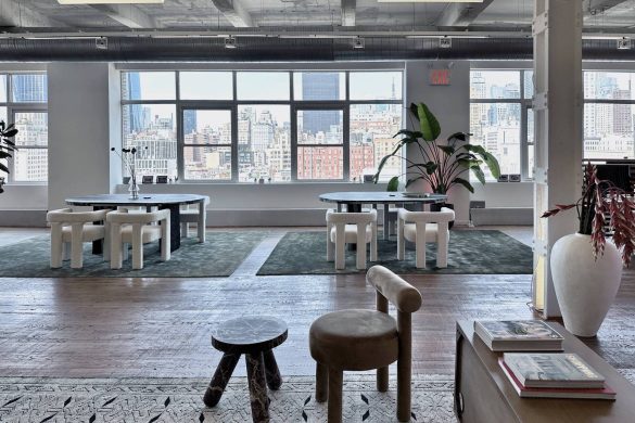 Otvoren poslovni prostor sa velikim prozorima, stolovima za sastanke i pogledom na Menhetn