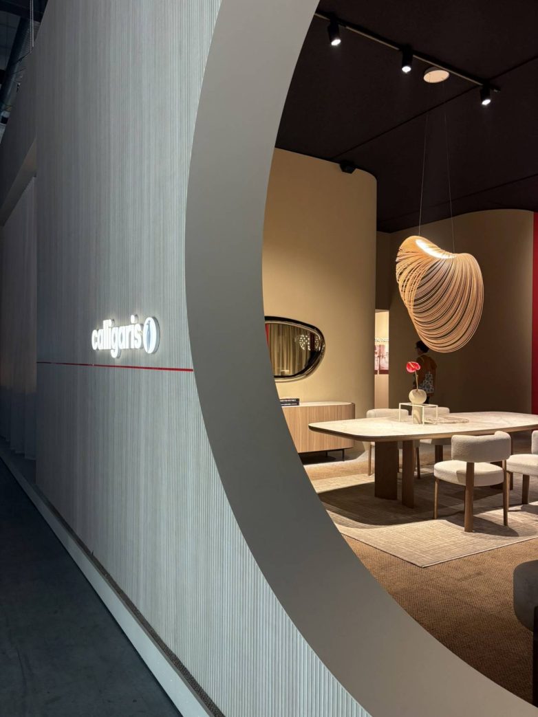 Izložbeni prostor Calligaris sa trpezarijskim stolom, svetlom instalacijom i zaobljenim arhitektonskim elementima