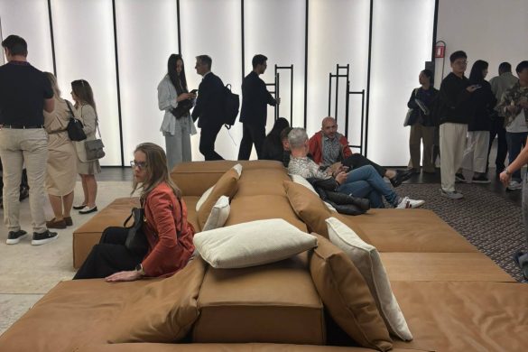 Posetioci sajma sede na velikoj modularnoj sofi u toplim tonovima na Salone del Mobile 2026