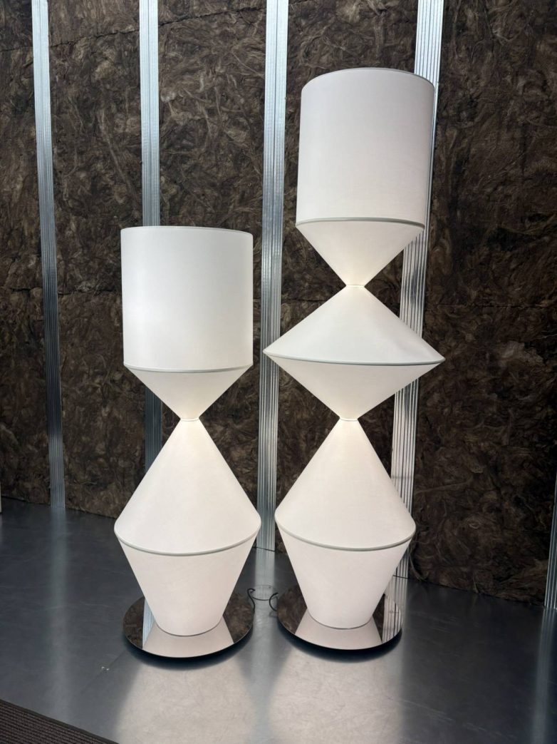 Dve visoke lampe brenda Mogg sa geometrijskim, skulpturalnim formama postavljene na postamentu