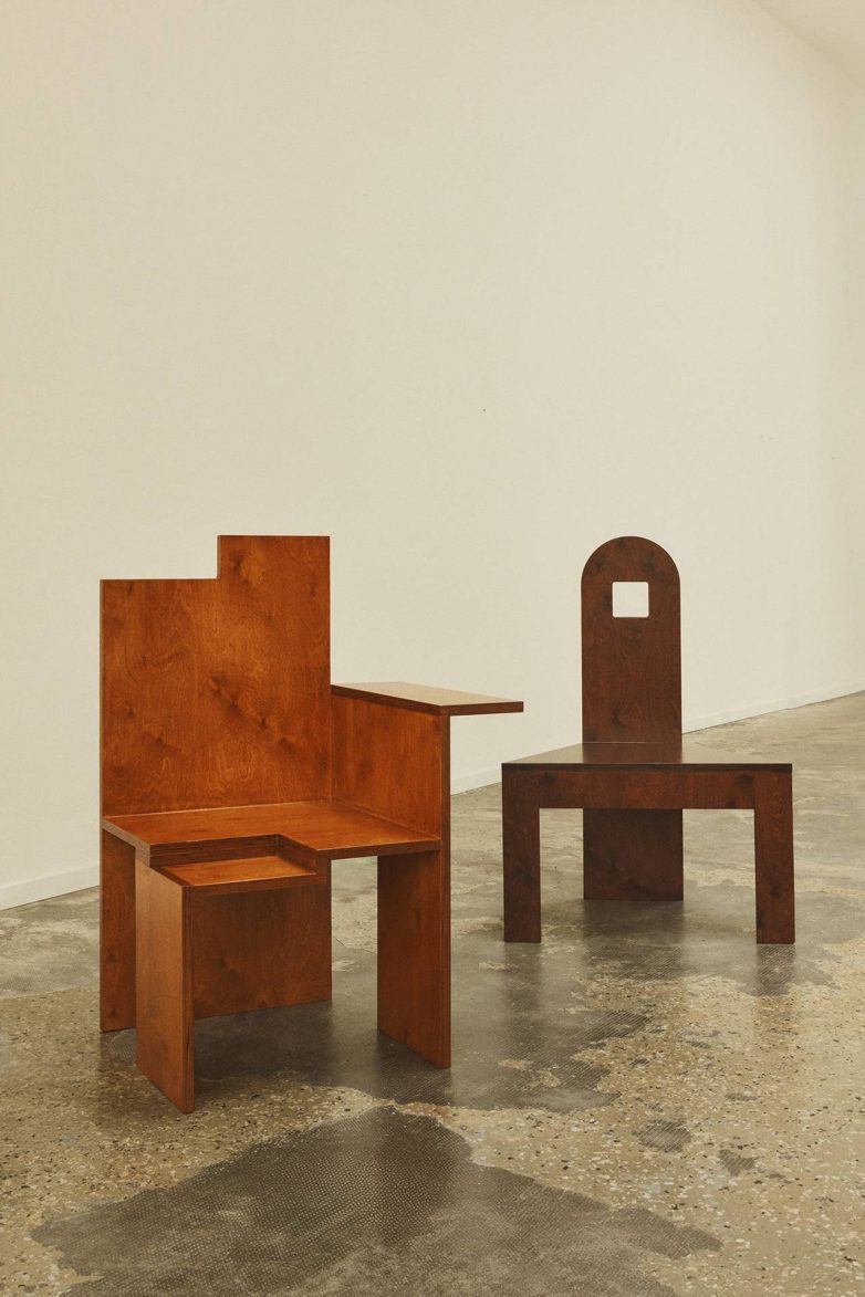 Dve drvene stolice neobičnog oblika iz kolekcije Bad Posture Chairs postavljene u minimalističkom enterijeru