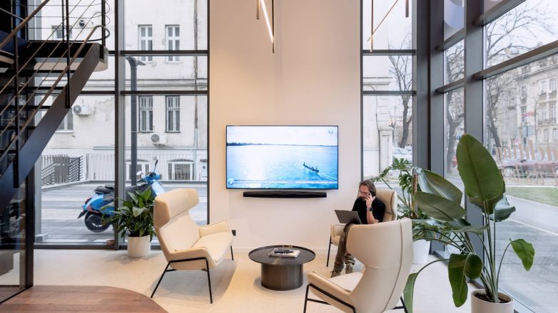 "Lounge" zona u salonu Yachting One u Beogradu sa foteljama, klub stolom, televizorom i velikim staklenim izlozima.