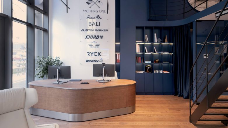 Ulazni deo salona Yachting One u Beogradu sa zakrivljenim drvenim pultom, policama i brendingom na zidu.