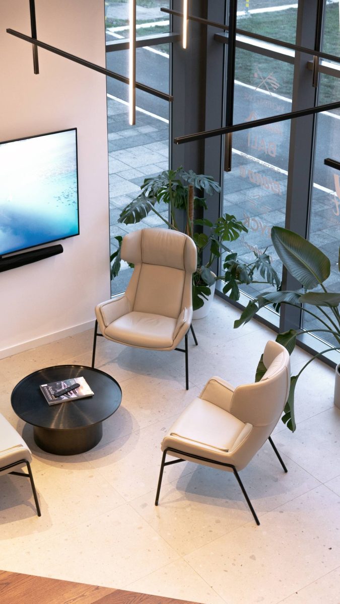 "Lounge" zona u salonu Yachting One u Beogradu sa dve svetle fotelje, klub stolom i biljkama pored staklene fasade