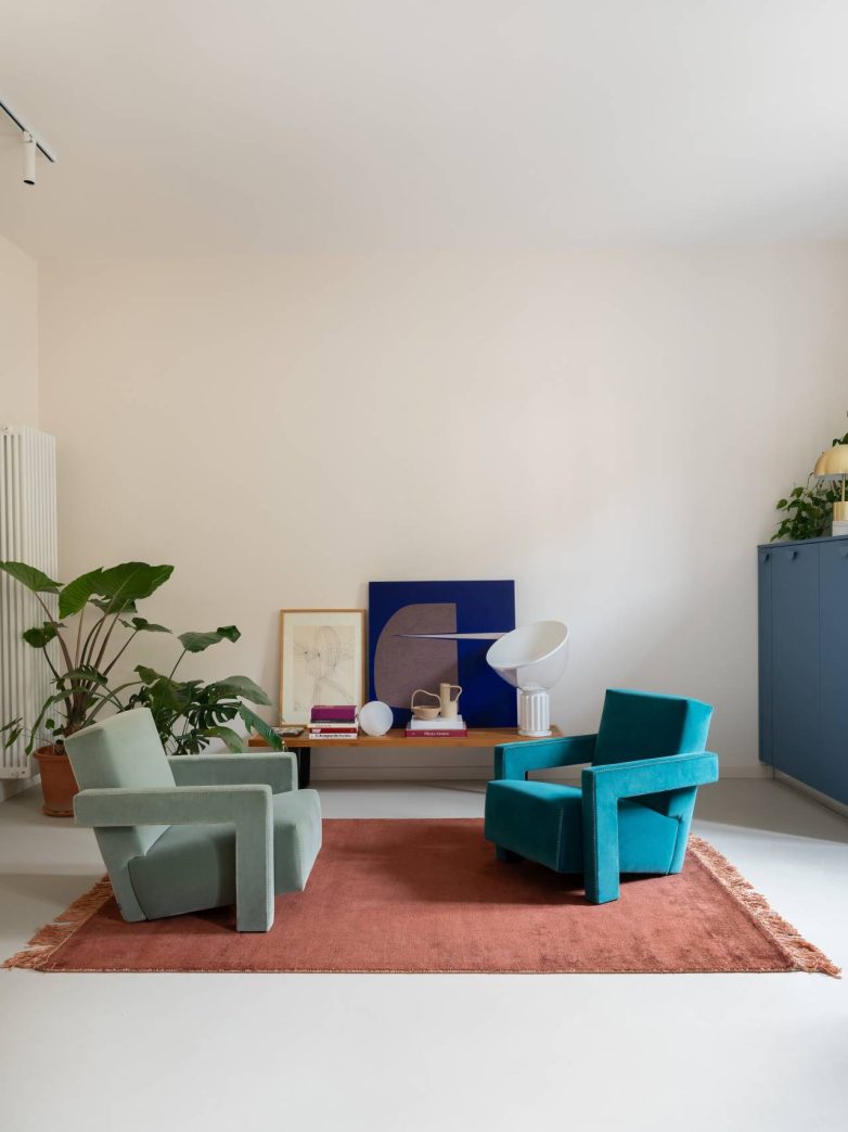 Dnevni boravak u rimskom stanu Casa Garbatella uređen je sa dve Utrecht fotelje, niskom klupom, tepihom i biljkama.