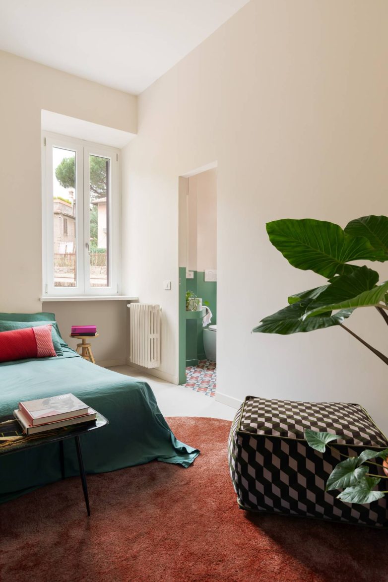 Spavaća soba u stanu Casa Garbatella u Rimu povezana je sa zelenim kupatilom i uređena u mirnim tonovima sa izraženim detaljima u boji.