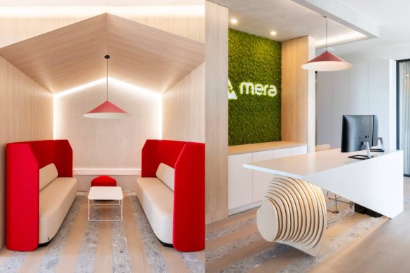 Centralna zona poslovnog prostora kompanije Mera u Zrenjaninu sa "lounge" delom, prijemnim pultom, crvenim detaljima i zelenim zidom sa logotipom.