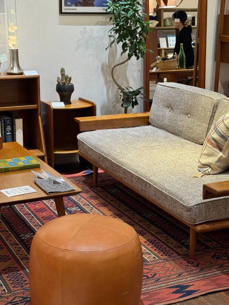 Kompaktna sofa od drveta i tekstila u japanskom enterijeru sa toplim zemljanim tonovima i retro detaljima.