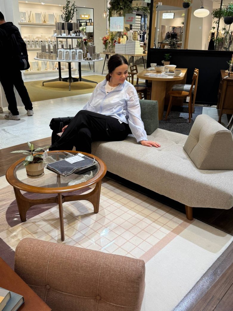 Multifunkcionalna sofa neutralnih tonova u japanskom salonu nameštaja sa kompaktnim drvenim stolom.