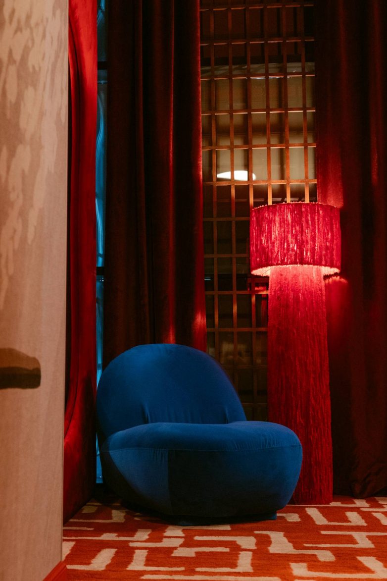 "Lounge" detalj restorana GOAT u Banjoj Luci sa plavom foteljom, crvenim zavesama, crvenom podnom lampom i tepihom geometrijskog dezena, projekat studija JB architect