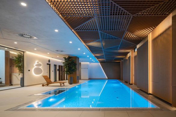 Enterijer SPA zone sa bazenom u privatnoj stambenoj zgradi u Zemunu, sa drvenim raster plafonom, integrisanom rasvetom i toplim zidnim oblogama