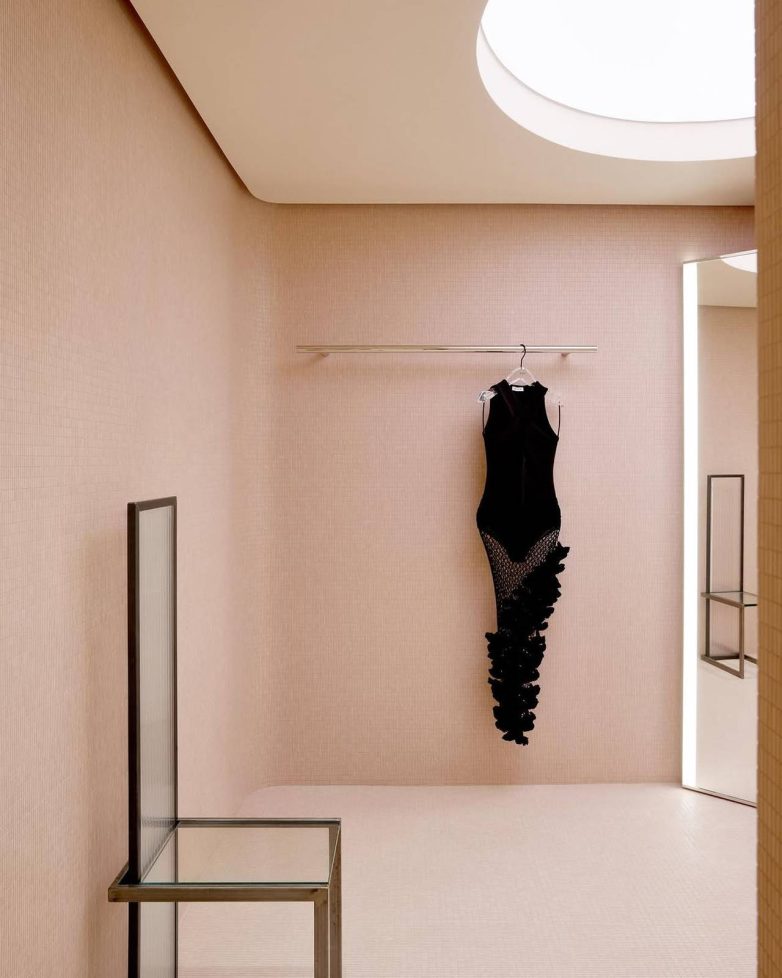 Enterijer Alaïa butika u Majamiju sa ružičastim mozaik pločicama, zaobljenim plafonom, kružnim svetlom i minimalističkim izložbenim elementima