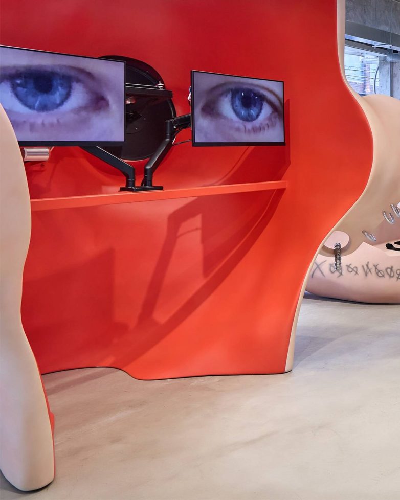 Crveni enterijer H&M prodavnice u Seulu sa ekranima na kojima su prikazane oči