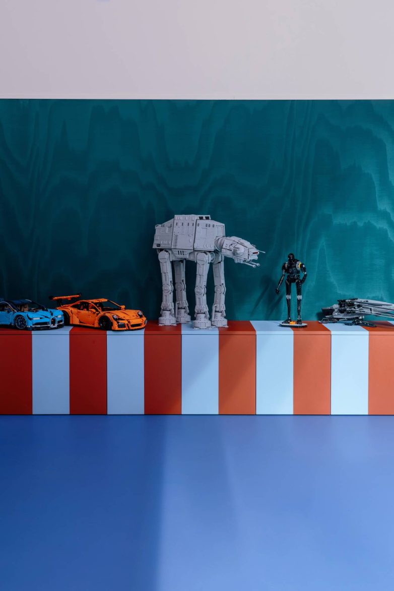 LEGO modeli izloženi na prugastom ormariću u sobi za zabavu kuće P1