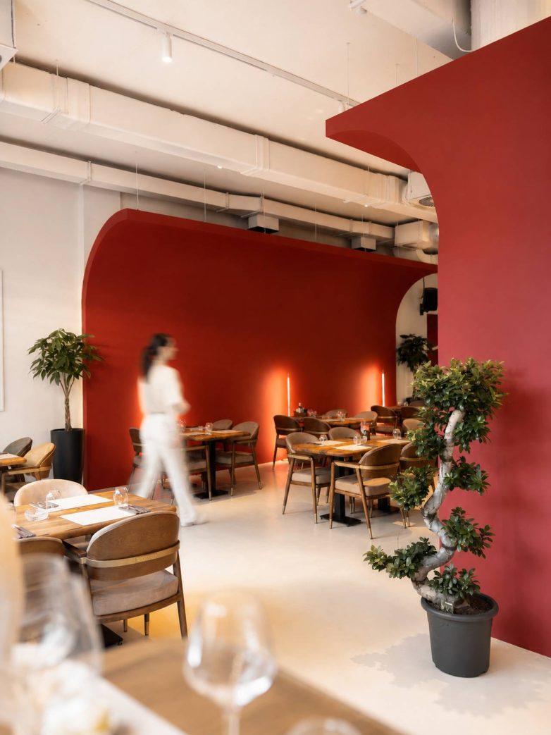 Enterijer restorana Zdravko sa crvenim lukovima i drvenim nameštajem